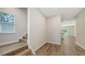 Bright foyer with wood-look floors, a staircase, and an open view to the main living area at 2926 River Run Way, Bradenton, FL 34208