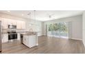 Open-concept kitchen with white cabinets, granite countertops, and stainless steel appliances at 2926 River Run Way, Bradenton, FL 34208