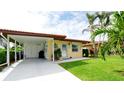 Inviting single-story home with a carport, well-maintained lawn, and attractive curb appeal showcasing beach-themed decorations at 3112 Cambridge Ave # 6, Bradenton, FL 34207