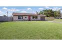 Single-story home with a lush green lawn, stone accents, and a red front door at 3123 40Th W Ave, Bradenton, FL 34205