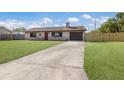 View of a single-story home with a well-manicured lawn and a long driveway leading to a garage at 3123 40Th W Ave, Bradenton, FL 34205