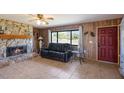 Cozy living room featuring a stone fireplace, wood paneling, and comfortable seating at 3123 40Th W Ave, Bradenton, FL 34205