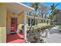 Inviting front entrance with a red door, white pillar, and stone-lined landscaping at 322 S Washington Dr, Sarasota, FL 34236