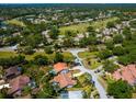 An aerial view of the home in relation to a golf course and the surrounding neighborhood, showing proximity to amenities at 3786 Surrey Ln, Sarasota, FL 34235