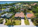 Aerial view of home with tile roof, screened in lanai and pool, surrounded by lush landscaping and trees at 3786 Surrey Ln, Sarasota, FL 34235