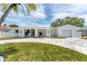 Beautiful home featuring a paved driveway, lush lawn, and modern architectural details at 3941 14Th Ne Ln, St Petersburg, FL 33703