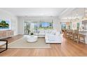 Bright and spacious living room with hardwood floors, white sofa, and access to outdoor patio at 4104 Las Palmas Way, Sarasota, FL 34238