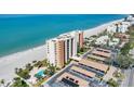 Breathtaking aerial view showcasing the beachfront condo building, pool, parking and pristine sandy beach at 4401 Gulf Of Mexico Dr # 907, Longboat Key, FL 34228
