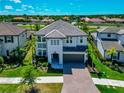 An aerial view of a two-story home with a paved driveway, lush lawn, and well-kept landscaping at 4881 Antrim Dr, Sarasota, FL 34240