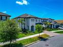 Two-story home with a two-car garage, well-manicured landscaping, and a brick paved driveway at 4881 Antrim Dr, Sarasota, FL 34240