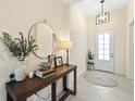 Inviting foyer with light tile flooring, console table, and stylish light fixture at 5406 Coral Reef Way, Lakewood Ranch, FL 34211