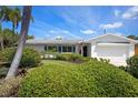 Charming single-story home with an American flag, tropical landscaping, and a well-maintained front lawn at 5523 Scotia Pl, Sarasota, FL 34231
