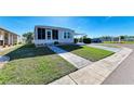 Single story home with a well maintained lawn and concrete pathway to the entry at 5619 Bayshore Rd # 152, Palmetto, FL 34221