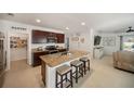 Kitchen with granite countertops, island with seating, dark cabinets, stainless steel appliances, and a walk-in pantry at 5868 Calla Lilly Dr, Sarasota, FL 34232