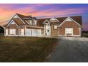 Charming brown two-story home with stone accents, and a spacious three-car garage at dusk at 5949 225Th E St, Bradenton, FL 34211