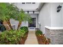 A pathway leading to a lovely front door with a garden featuring palm trees and lush plants at 6473 Baytown Dr, Sarasota, FL 34240