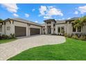 A well-manicured lawn and long driveway lead to this home with a three-car garage at 9241 Starry Night Ave, Sarasota, FL 34241