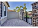 An outdoor courtyard showcasing a stone wall, paved ground, stone columns, and an iron gate at 9914 Craftsman Park Way, Palmetto, FL 34221