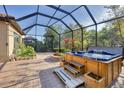 Screened-in patio features a large hot tub with steps and a water feature, alongside brick planters at 9914 Craftsman Park Way, Palmetto, FL 34221