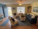 Cozy living room featuring hardwood floors, a blue sofa, and two decorative accent chairs at 1007 Pussywillow Ln, Bradenton, FL 34208