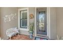 Inviting front entrance features a decorative glass door, chair and potted plant at 11176 Roseate Ct, Sarasota, FL 34238