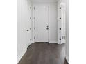 Inviting hallway featuring hardwood floors, white trim, doors and neutral walls at 11214 Sandhill Preserve Dr, Sarasota, FL 34238