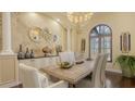 Bright dining room featuring textured walls, statement lighting, and a wooden table with seating for six at 113 Fillmore Dr, Sarasota, FL 34236