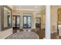 Open foyer with dark wood floors, arched doorways, and french doors leading to the outdoor living space at 113 Fillmore Dr, Sarasota, FL 34236