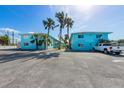 Charming light blue two-story building with palm trees and ample parking at 117 7Th N St # 35, Bradenton Beach, FL 34217