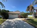 Well-maintained single-story home featuring a long driveway and tropical landscaping at 11811 53Rd Ct E, Parrish, FL 34219
