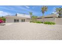 Exterior showcasing a modern home with a gravel driveway, a two-car garage, and a lush green landscape at 1186 Center Pl, Sarasota, FL 34236