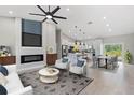 Open-concept living room with a modern fireplace, large-screen TV, and contemporary furniture at 13552 Boatbill Ln, Port Charlotte, FL 33981