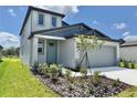 Charming front exterior showcasing stylish siding, a tidy lawn, and a convenient two-car garage at 14057 Crutchfield Ct, Parrish, FL 34219