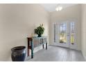 Bright foyer with a decorative glass entry door, stylish console table, and neutral tile flooring at 16139 69Th E Ln, Parrish, FL 34219