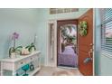 Bright entryway with light blue walls, decorative table, and a view of the landscaped front yard at 21287 Sandal Foot Dr, Venice, FL 34293