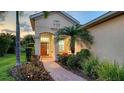 Charming front entrance with a brick walkway, manicured landscaping, and a welcoming front door at 21287 Sandal Foot Dr, Venice, FL 34293