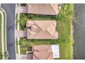 Aerial shot of a single Gathering home with a tile roof, green lawn, and situated on a lake at 2212 Weaver Bird Ln, Venice, FL 34292