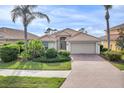 Charming single-story home featuring a beautiful tile roof, paver driveway, and well-manicured landscaping at 2212 Weaver Bird Ln, Venice, FL 34292