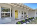 Inviting front porch with a bright yellow door, stylish seating, and thoughtful landscaping at 2220 Palm Ter, Sarasota, FL 34231