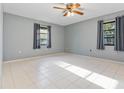 Bright bedroom featuring tile floors, a ceiling fan, neutral-colored walls, and two large windows at 2272 Palomar St, North Port, FL 34287