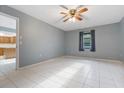 Bedroom featuring tile flooring, ceiling fan, light blue walls, and access to the kitchen at 2272 Palomar St, North Port, FL 34287