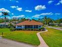 Charming single-story home with a well-manicured lawn, screened lanai, and inviting walkway at 2305 Riverview Blvd, Bradenton, FL 34205