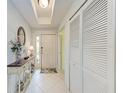 Bright foyer features a console table, closet, and neutral tile flooring at 23261 Banbury Way # 501, Venice, FL 34293