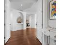 Inviting foyer features a white console table, dark hardwood floors, and an arched entryway at 2333 Gulf Of Mexico Dr # 1A2, Longboat Key, FL 34228