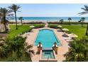 An aerial view of a pool and spa with beach access and lush landscaping at 2333 Gulf Of Mexico Dr # 1A2, Longboat Key, FL 34228