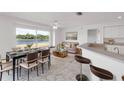 Dining area with a modern table set, scenic water view, and open to the breakfast bar and kitchen at 2435 E Del Webb Blvd, Sun City Center, FL 33573