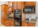 Well-equipped kitchen featuring custom cabinets, granite countertops, and stainless steel appliances at 2817 La Mancha Ct, Punta Gorda, FL 33950