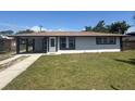 Charming single-story home featuring a well-manicured lawn, covered carport, and freshly painted exterior at 2919 Bayshore Gardens Pkwy, Bradenton, FL 34207