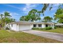 Spacious home with an attached garage, a large driveway, and mature landscaping at 320 25Th W St, Bradenton, FL 34205