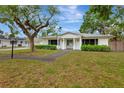 Traditional home featuring a lush front yard, mature trees, and a bright exterior at 320 25Th W St, Bradenton, FL 34205